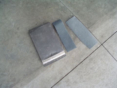 1999 Ford Taurus - Metal sheet and sandpaper strips are laid out on a concrete surface.