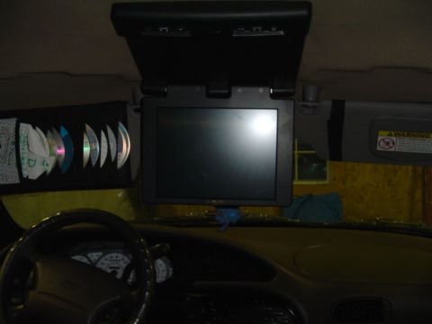 1999 Ford Taurus - Interior view of a car's dashboard and headliner, equipped with an entertainment system and CD storage.