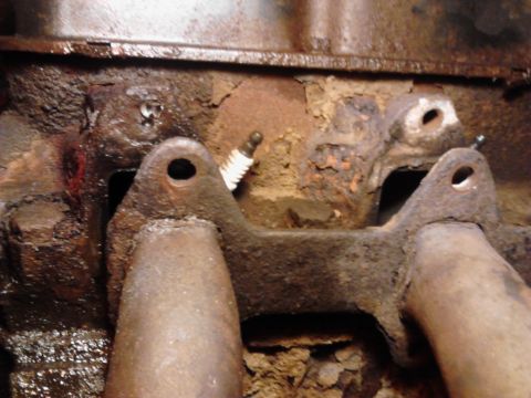 1973 Ford F-250 - Engine exhaust manifold showing rust and a spark plug.