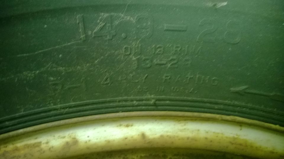 Close-up of tire sidewall showing size 14.9-28 and 4 PLY RATING
