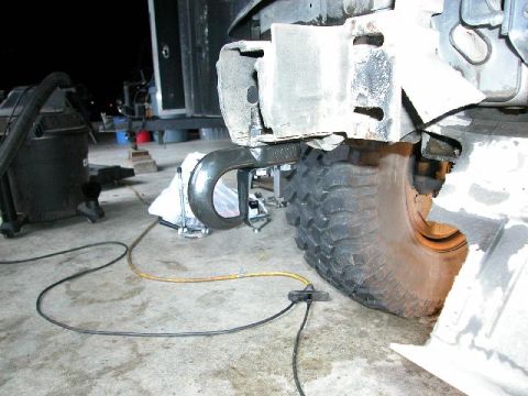1995 Ford Bronco - A vehicle's front tow hook and tire are shown, with electrical cables connected to the hook assembly.