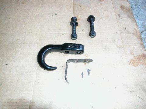 1995 Ford Bronco - A black tow hook, two bolts, and a metal bracket are laid out on a textured surface. The tow hook is marked with "MAX LOAD 10000 LB".