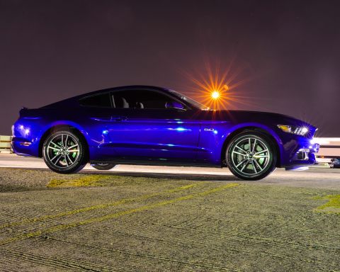 2015 Ford Mustang - Side profile of a blue 2015 Ford Mustang coupe under artificial lighting at night.