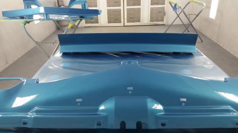 2015 Chevrolet new - A blue car hood and spoiler are seen in a paint booth, possibly awaiting further work.