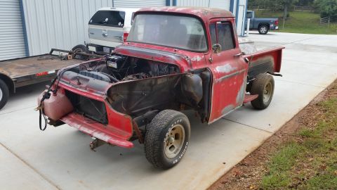2015 Chevrolet new - This old red pickup truck is in a state of disrepair, with its hood and front fenders removed.