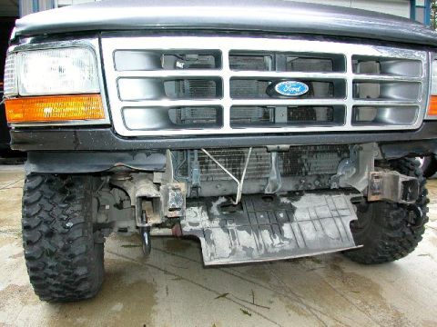 1995 Ford Bronco - The front recovery hooks are visible on this 1992 Ford Bronco, which has a damaged bumper and exposed radiator.