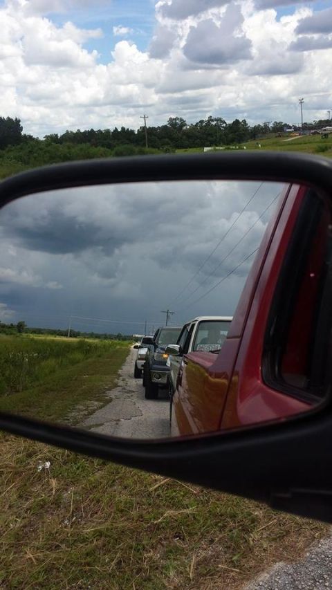 1995 Ford Bronco - Traffic jam on a rural road, viewed from a vehicle's side mirror.
