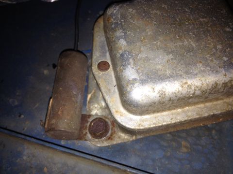 1973 Ford Bronco - A close-up view of a corroded voltage regulator, showing its metallic texture and mounting hardware.