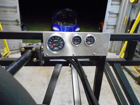 1992 Ford Bronco - Custom gauge panel with tachometer and other gauges, with a blue car visible in the background.