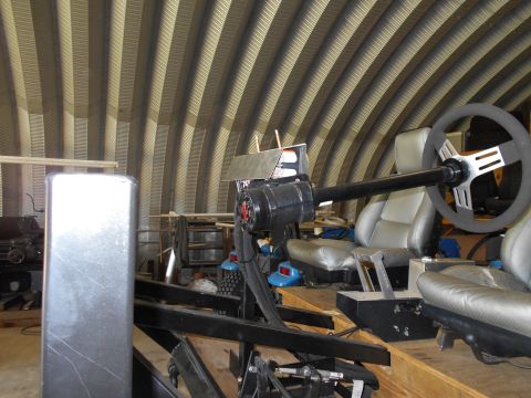1992 Ford Bronco - A custom racing simulator is set up inside a workshop with a corrugated metal ceiling.