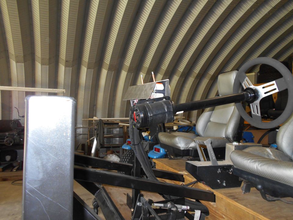 custom racing simulator with bucket seats and steering wheel in a workshop