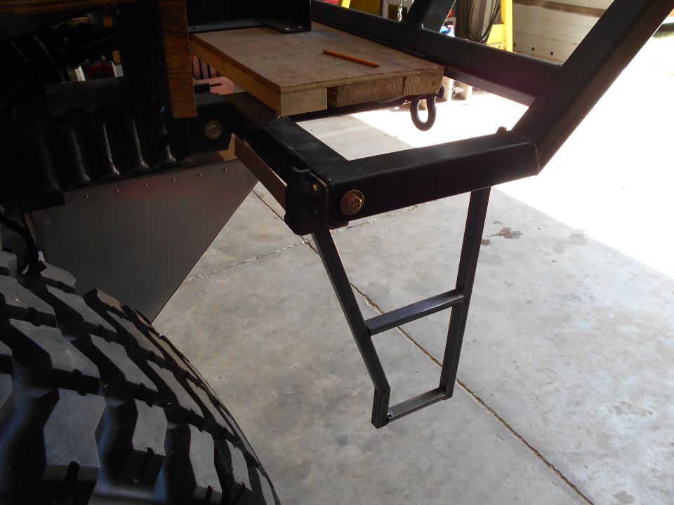 Black metal rear step and large off-road tire on a vehicle
