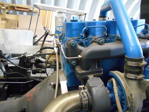 1992 Ford Bronco - Close-up view of a blue engine component, likely a turbocharger and associated plumbing, with a Supermotors.net watermark.
