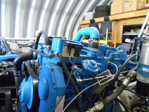 1992 Ford Bronco - Close-up of a blue engine assembly, showing various components and plumbing.