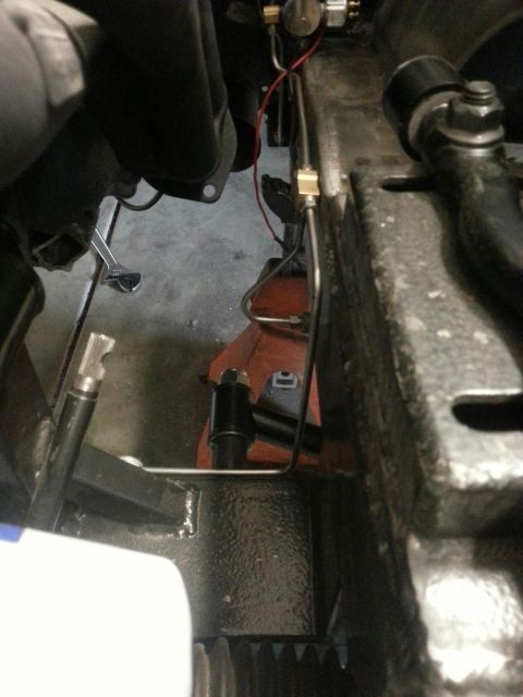 1964 Ford Fairlane - Undercarriage view of a vehicle's frame and brake lines, supported by a jack stand.