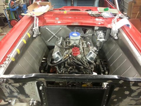 1964 Ford Fairlane - Engine bay of a 1964 Ford Fairlane undergoing restoration, showing a V8 engine and custom metalwork in progress.