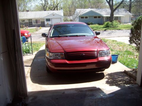 2004 Ford Crown Victoria - A red sedan is parked in a driveway, viewed from the front.