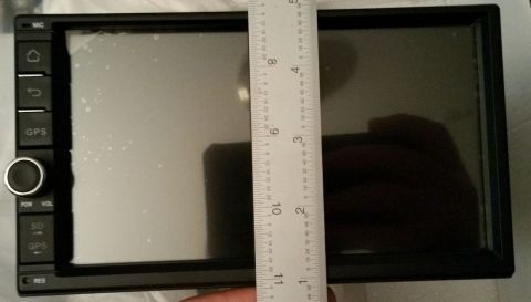 2001 Ford Excursion - A car stereo head unit is shown with a ruler to indicate its dimensions. The unit has several buttons and a rotary knob.