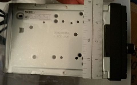 2001 Ford Excursion - A ruler measures the width of a car stereo chassis, which is labeled with model and serial numbers.