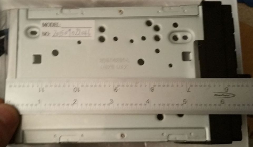 Rear of car stereo unit with ruler measuring dimensions