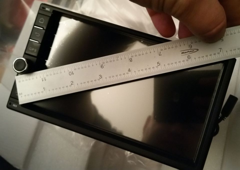 Car stereo screen being measured by a ruler