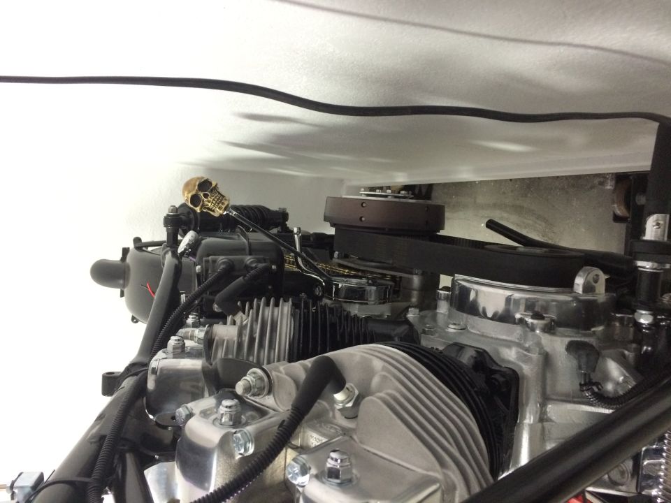 Close-up of a V-twin motorcycle engine with a small skull ornament on top