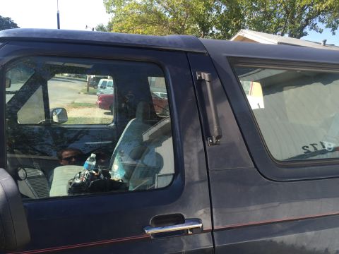 1993 Ford Bronco - Interior view of a dark blue SUV, showing the passenger seat with a water bottle and bags.