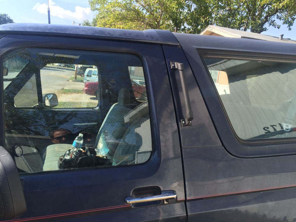 Interior view of a 1993 Ford Bronco showing seats and a person in the driver's seat