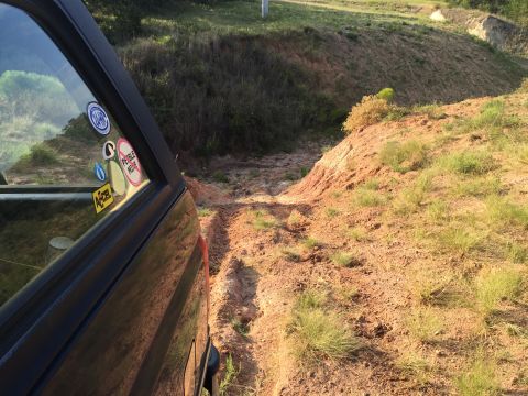 1993 Ford Bronco - SUV navigating a challenging off-road path with steep, muddy inclines.
