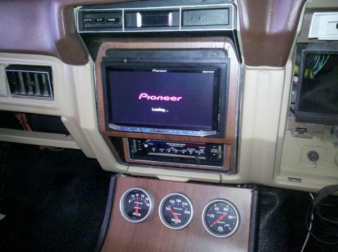 1982 Ford Bronco - The interior of a vintage vehicle shows a Pioneer car stereo with a loading screen and three gauges below: volts, water temperature, and oi…