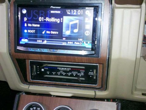 1982 Ford Bronco - The interior of a vehicle shows a Pioneer car stereo system with a digital display and a climate control unit below it. The stereo displays…