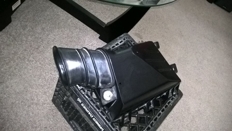 Black plastic air intake part on a milk crate