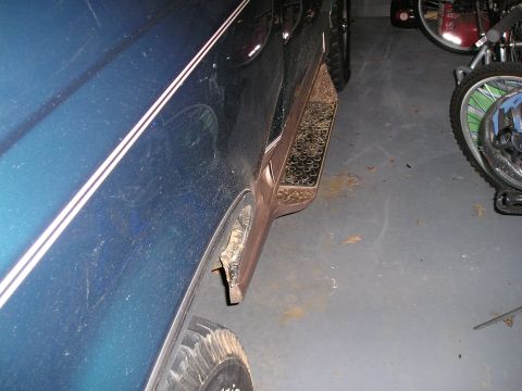 1996 Ford Bronco - The side of a blue 1996 Ford Bronco with white pinstripes is visible, along with a running board and wheel well.