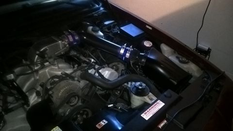2004 Ford Crown Victoria - The engine bay shows a newly installed cold air intake system with black piping and a purple clamp.