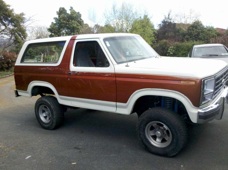 1980s Ford Bronco, two-tone brown and white, lifted suspension, side view
