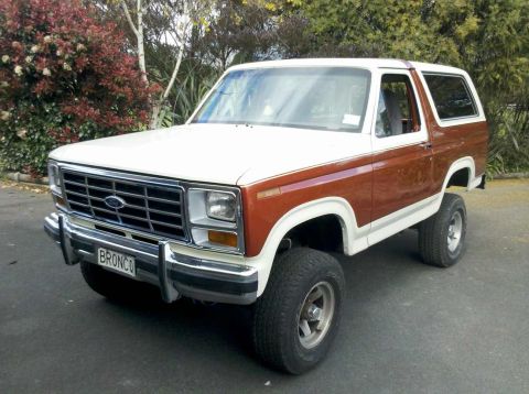 1982 Ford Bronco - This lifted Ford Bronco features a two-tone paint scheme with brown and white sections.