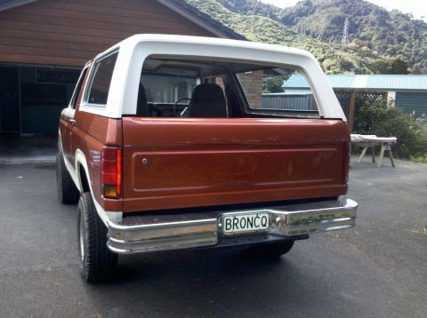 1982 Ford Bronco - Rear view of a brown and white Ford Bronco, identified by its license plate.