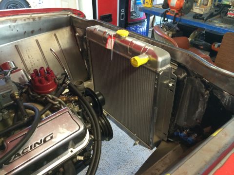 1964 Ford Fairlane - New aluminum radiator installed in a V8 engine bay with chrome valve covers and red distributor.