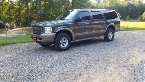 2003 Ford Excursion - This Ford Excursion is parked on a gravel driveway with trees and grass in the background.