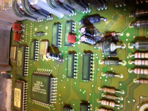 1994 Ford Bronco - A detailed view of an electronic control unit's circuit board, showing various electronic components and signs of wear.
