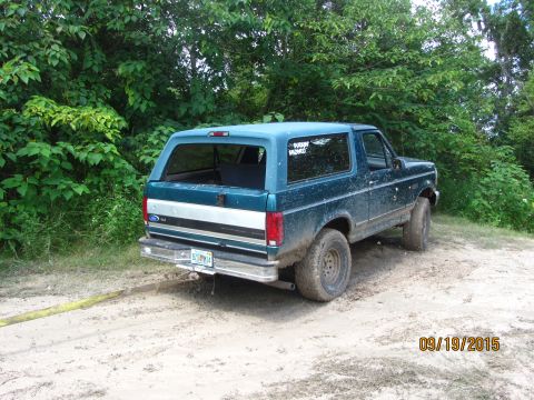 1996 Ford Bronco - This 1996 Ford Bronco is shown from the rear on a dirt path, with a tow strap attached.
