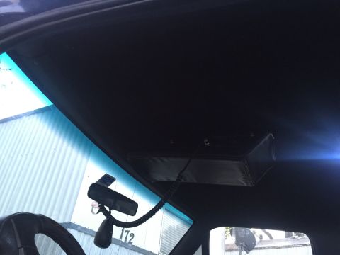 1993 Ford Bronco - View from inside a vehicle shows the overhead console and a rearview mirror mounted to the windshield.