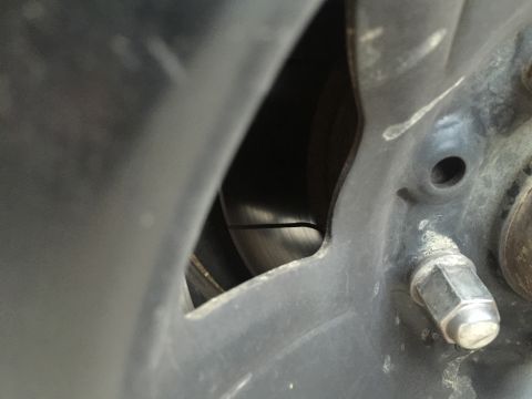 1993 Ford Bronco - Close-up view of a vehicle's wheel hub, brake rotor, and lug nuts.