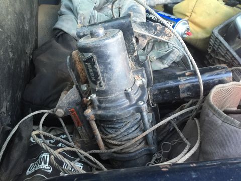 1993 Ford Bronco - A WARN winch with coiled cable and various items in the background.
