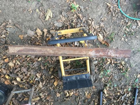 1993 Ford Bronco - A rusty metal beam is positioned on a yellow dolly outdoors.