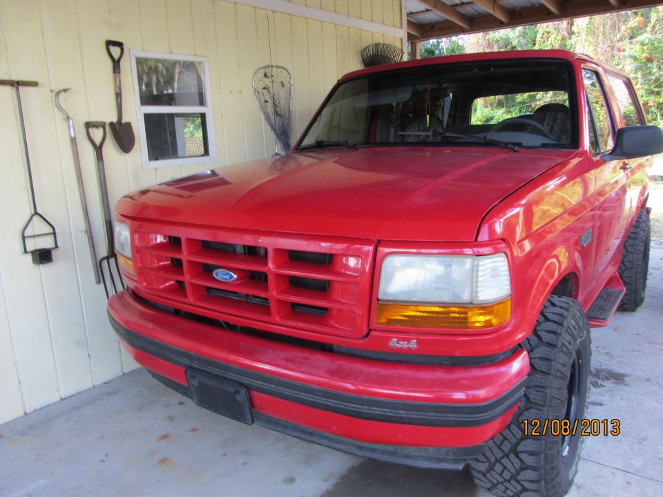 Red 1995 Ford Bronco 4x4 parked in a garage