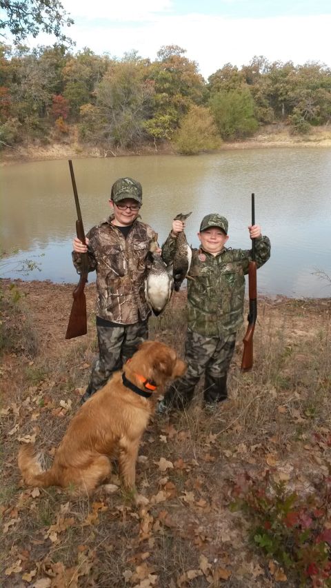 1993 Ford Bronco - Two young hunters and their dog proudly display their duck catch by the water's edge.