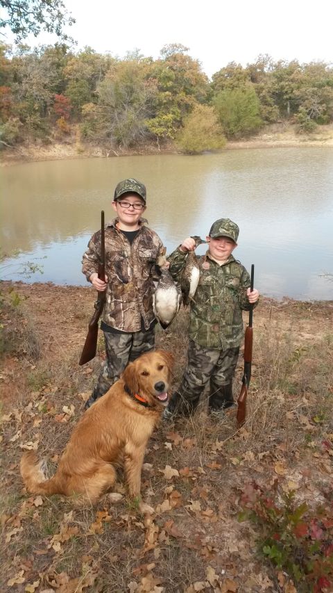 1993 Ford Bronco - Two young hunters and their dog proudly display their duck catch by the water's edge.