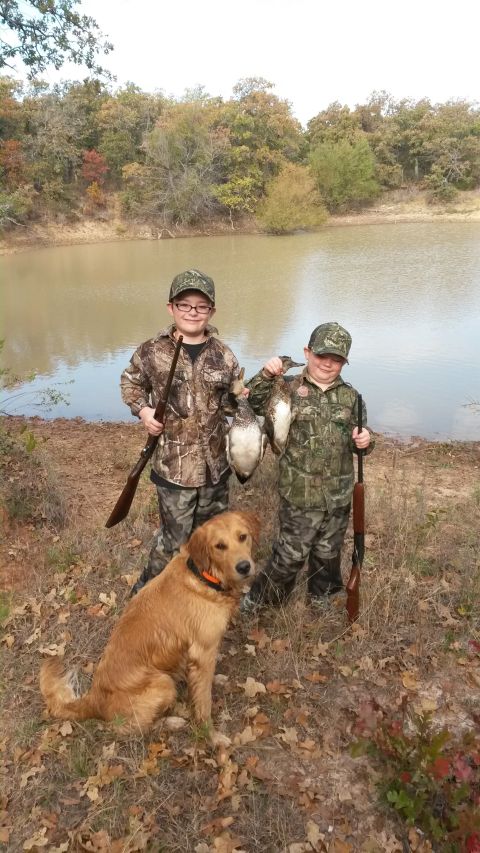 1993 Ford Bronco - Two young hunters and their dog pose with their catch by the water's edge.