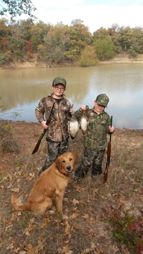 1993 Ford Bronco - Two young hunters and their dog pose with their catch by a pond.